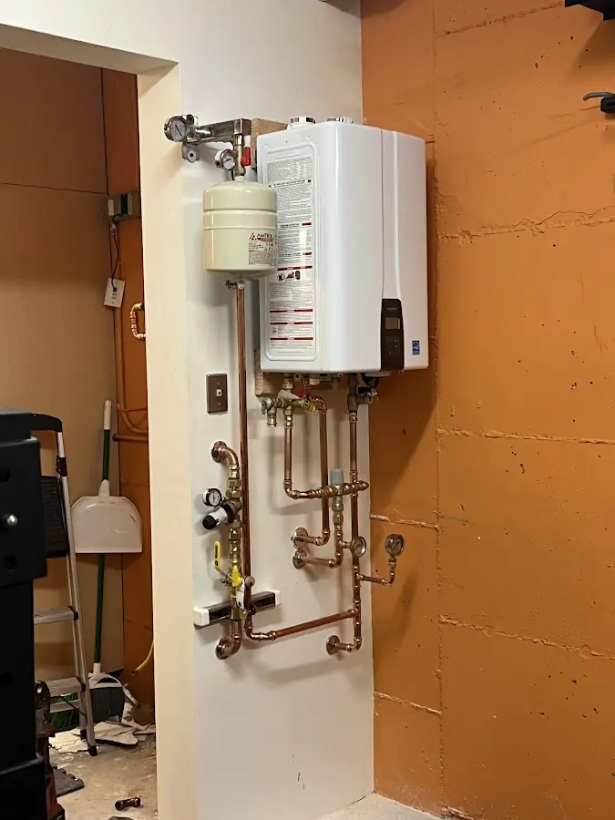 Plumbing technician inspecting water heater connections in Maplewood